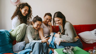 Photo d'étudiants qui rient et regardent un smartphone