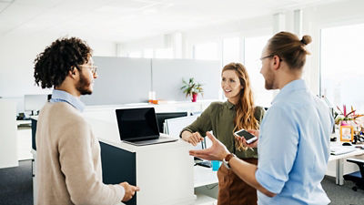 Photo d'employés qui échangent dans un open space